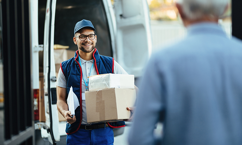 Young happy courier making a delivery to his customer.